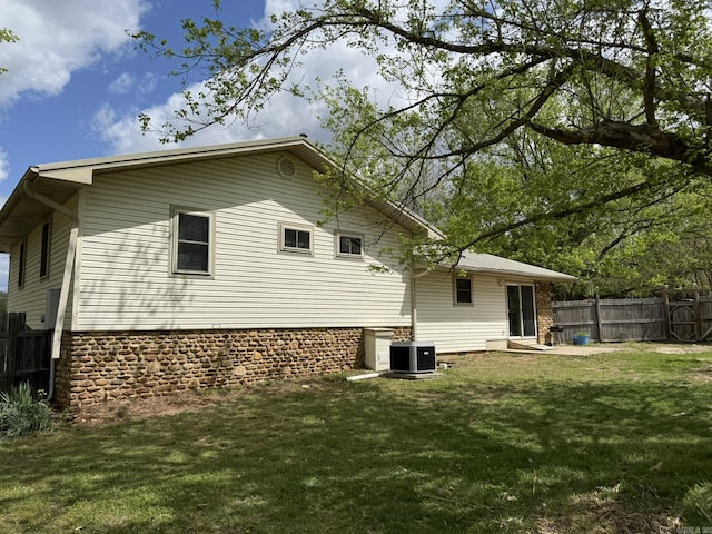 62 Ruby Ln, Melbourne, AR 72556 - back of house featuring central air condition unit, fence, and a lawn