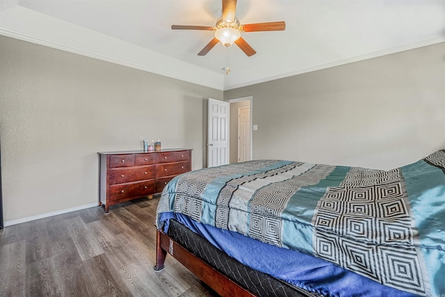 bedroom featuring ornamental molding, baseboards, a ceiling fan, and wood finished floors