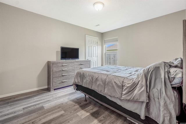 bedroom with light wood-style flooring, baseboards, and visible vents