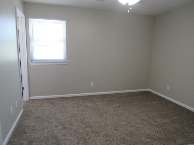 spare room with baseboards and carpet floors