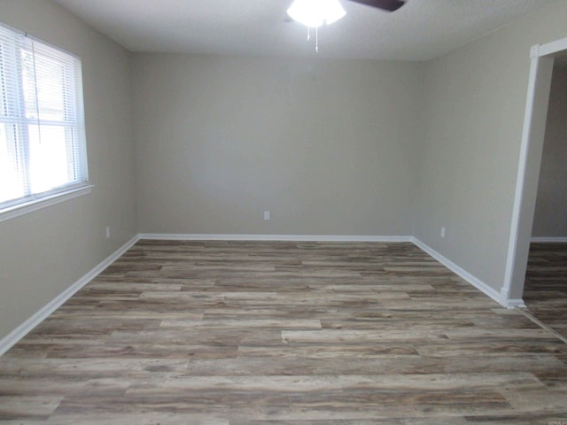 spare room with baseboards, a ceiling fan, and wood finished floors