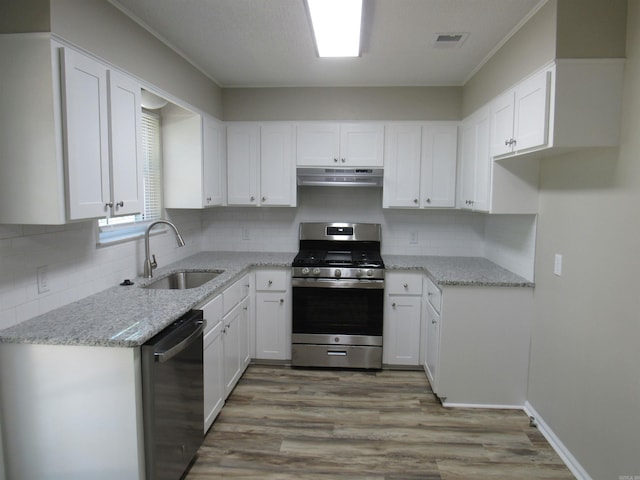 kitchen featuring visible vents, under cabinet range hood, stainless steel gas range, dishwasher, and a sink
