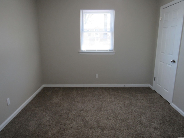 carpeted spare room featuring baseboards