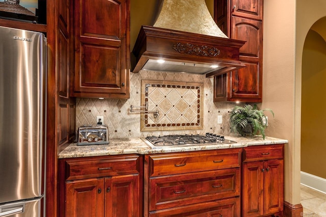 1130 Applewood Dr, Conway, AR 72034 - kitchen featuring light stone countertops, tasteful backsplash, stainless steel appliances, custom range hood, and baseboards