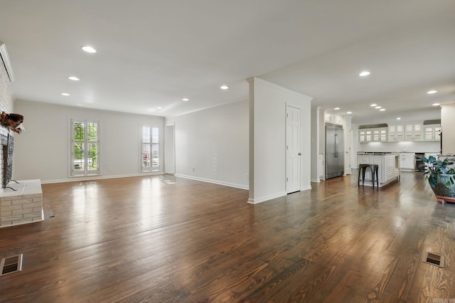 unfurnished living room featuring recessed lighting, visible vents, dark wood-style flooring, and baseboards