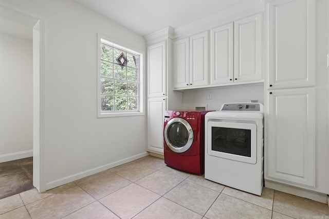 washroom with cabinet space, light tile patterned floors, baseboards, and separate washer and dryer