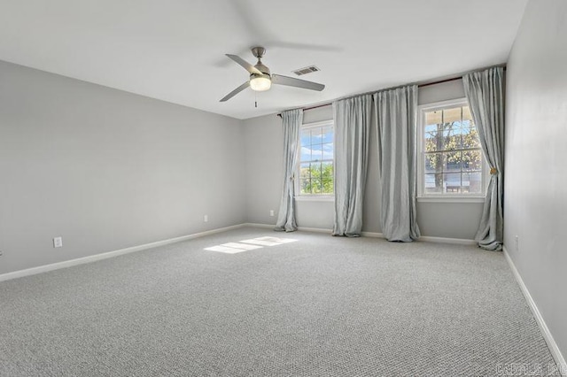 spare room with visible vents, ceiling fan, baseboards, and carpet