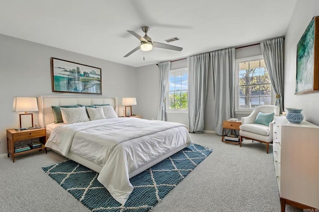 carpeted bedroom featuring visible vents, baseboards, and a ceiling fan