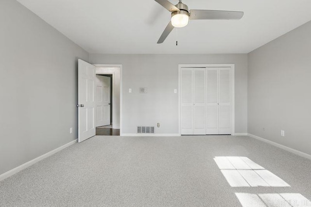 unfurnished bedroom featuring a closet, carpet flooring, baseboards, and visible vents