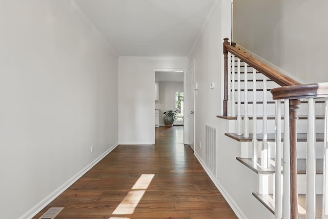 corridor featuring stairway, visible vents, ornamental molding, and wood finished floors
