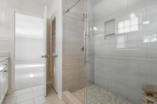 bathroom featuring a stall shower, vanity, and baseboards