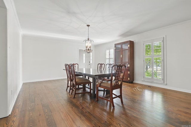 dining space with visible vents, baseboards, a notable chandelier, dark wood finished floors, and crown molding