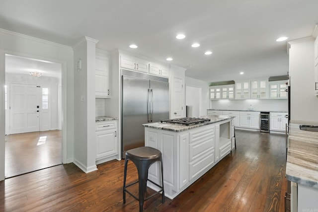 kitchen featuring dark wood-style floors, crown molding, white cabinets, wine cooler, and stainless steel appliances
