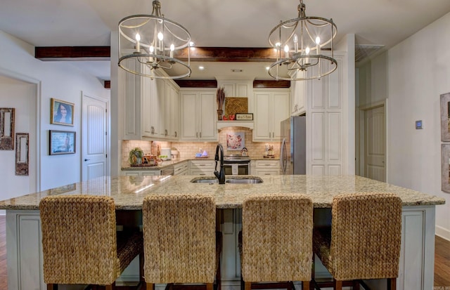 2136 Avondale, Benton, AR 72019 - kitchen with beamed ceiling, a notable chandelier, a sink, and freestanding refrigerator