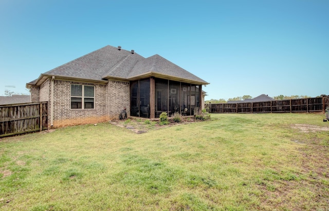 2136 Avondale, Benton, AR 72019 - rear view of property featuring a yard, brick siding, a fenced backyard, and a sunroom