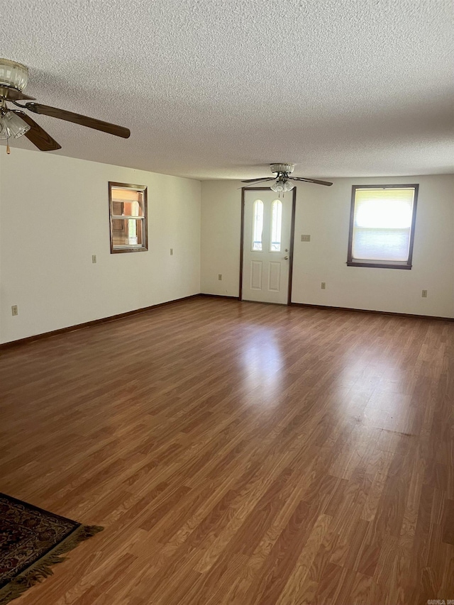 unfurnished living room featuring a textured ceiling, wood finished floors, and ceiling fan