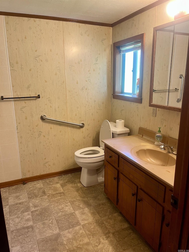 bathroom with toilet, vanity, and ornamental molding