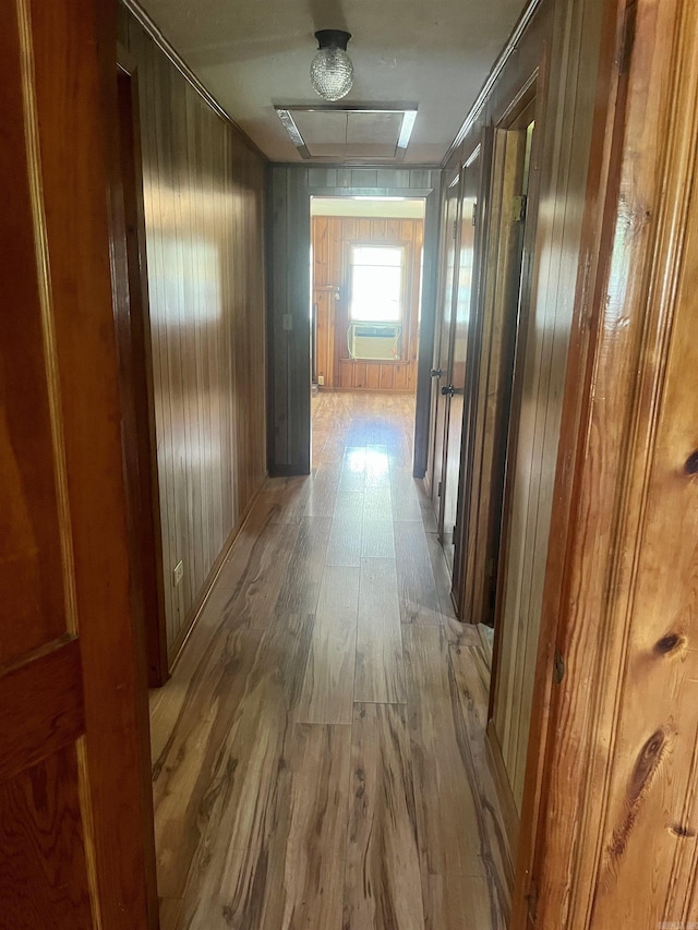 corridor with wood walls, cooling unit, and wood finished floors