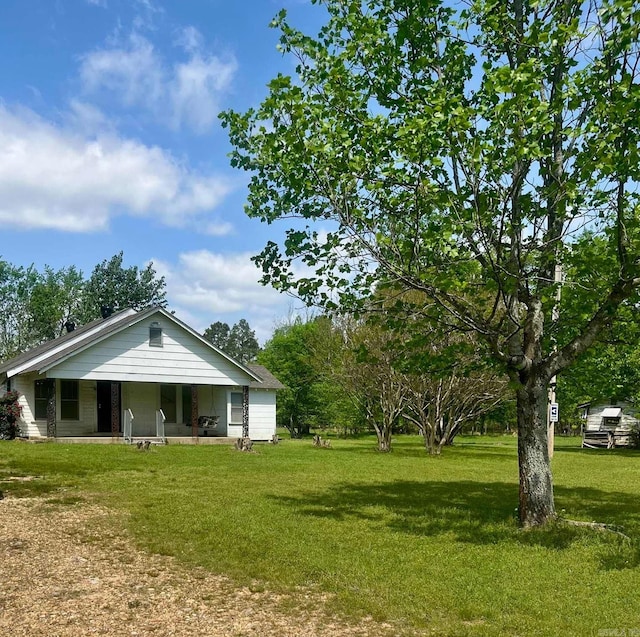 back of property with a porch and a lawn