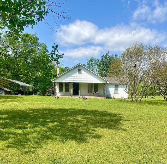 view of front of property with a detached carport and a front lawn