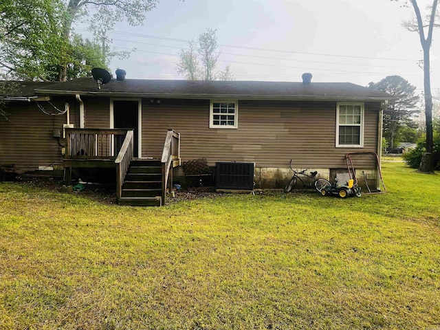 back of property with a wooden deck, a lawn, and central AC unit