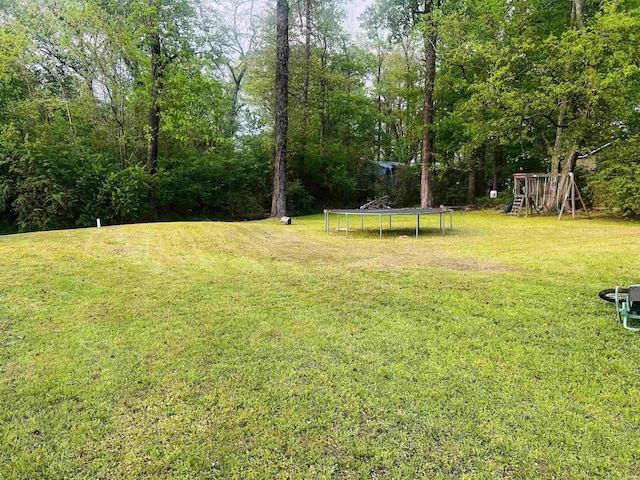 view of yard featuring a playground and a trampoline