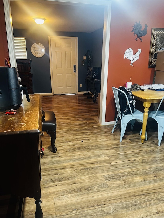 interior space featuring light wood-type flooring and baseboards