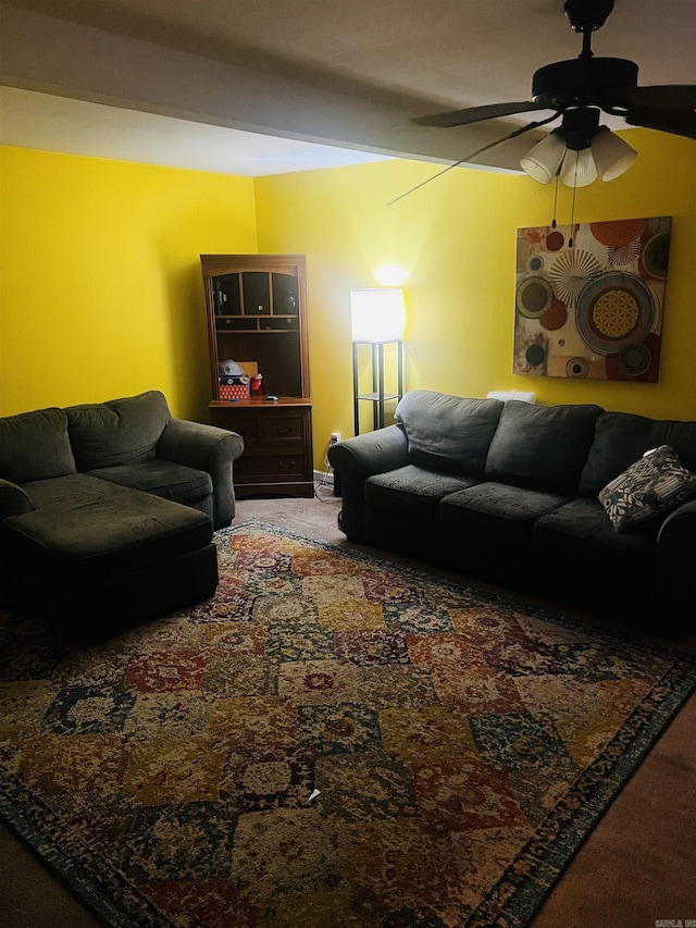 living area with a ceiling fan and carpet flooring