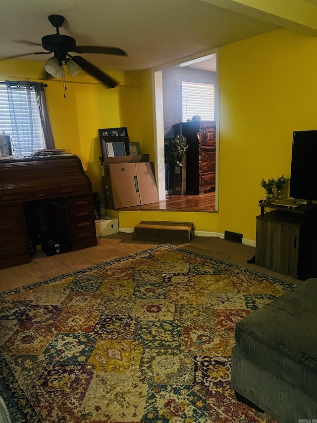 living area featuring plenty of natural light and ceiling fan