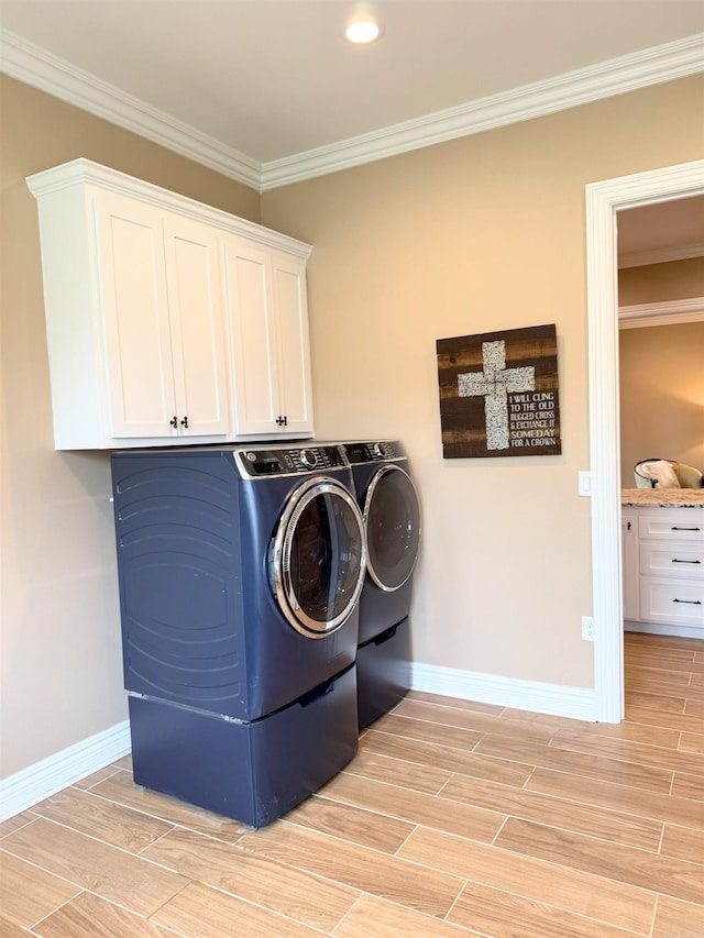 laundry room featuring baseboards, cabinet space, wood finish floors, and washer and clothes dryer