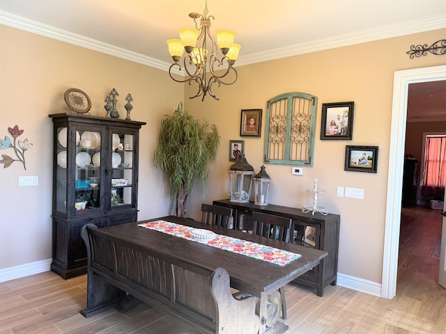 dining room featuring a chandelier, baseboards, and ornamental molding