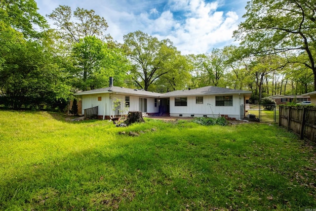 124 Hiawatha Dr, Little Rock, AR 72211 - back of house featuring a yard, fence, board and batten siding, and crawl space