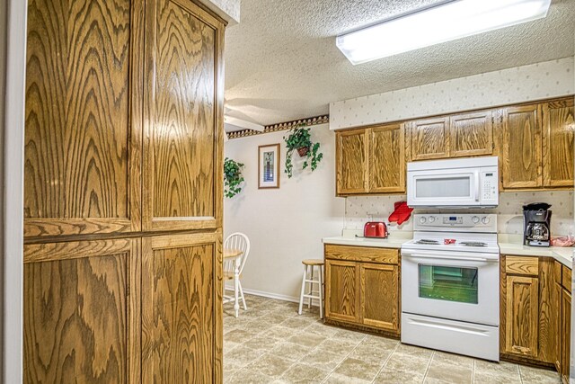 20 Cortez Way, Hot Springs Village, AR 71909 - kitchen featuring baseboards, light countertops, white appliances, a textured ceiling, and brown cabinetry