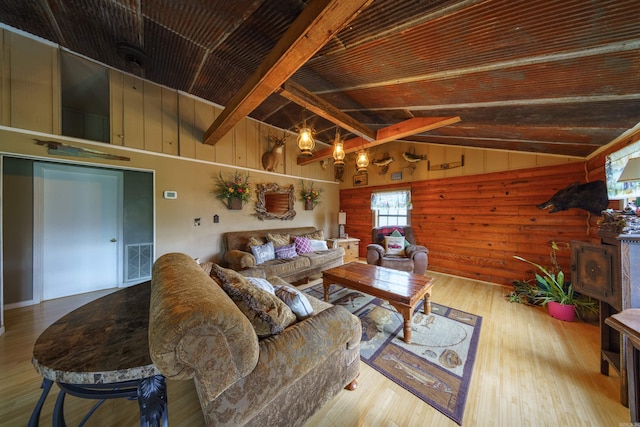 living room with visible vents, wood ceiling, wood finished floors, wood walls, and vaulted ceiling with beams