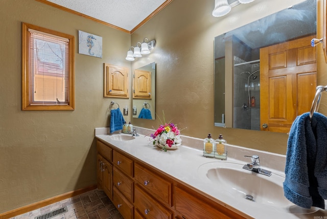 bathroom featuring a shower with door, baseboards, a sink, and ornamental molding