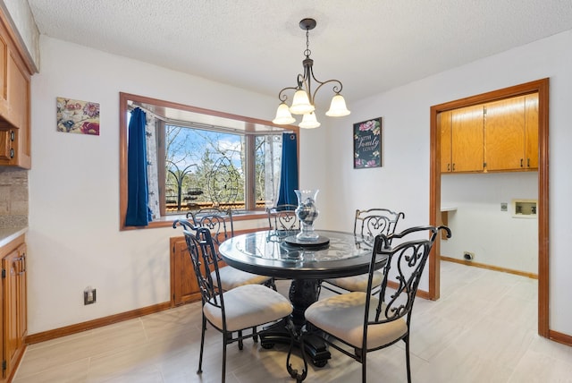 dining area with baseboards, an inviting chandelier, and a textured ceiling