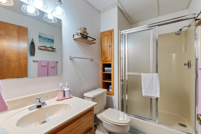 full bath with toilet, a paneled ceiling, a stall shower, and vanity
