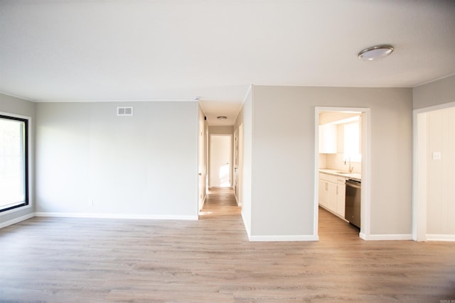 7204 W Wakefield Dr, Little Rock, AR 72209 - unfurnished living room featuring light wood-style flooring, baseboards, a sink, and visible vents