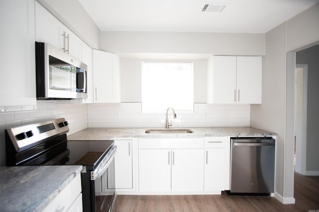 7204 W Wakefield Dr, Little Rock, AR 72209 - kitchen featuring visible vents, a sink, wood finished floors, stainless steel appliances, and decorative backsplash