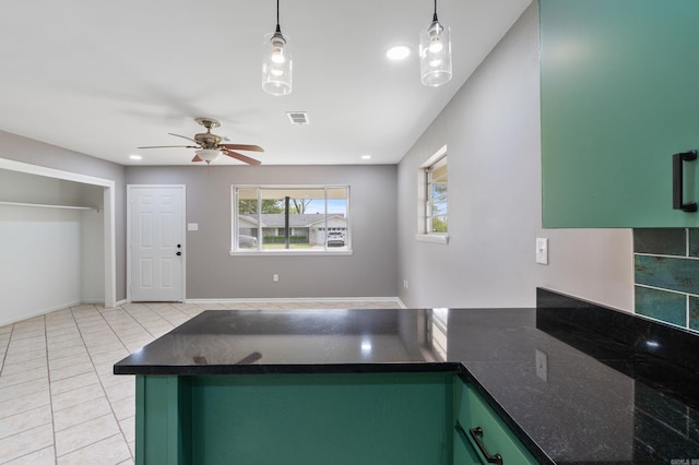 kitchen featuring a peninsula, light tile patterned flooring, visible vents, ceiling fan, and green cabinetry