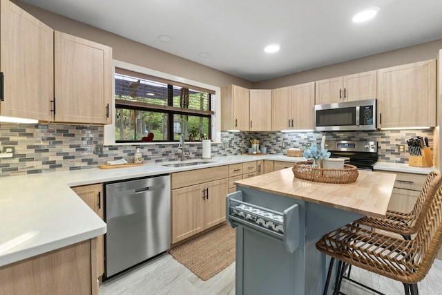 16 Valley Rd, Cabot, AR 72023 - kitchen with a kitchen breakfast bar, light brown cabinets, a sink, and appliances with stainless steel finishes