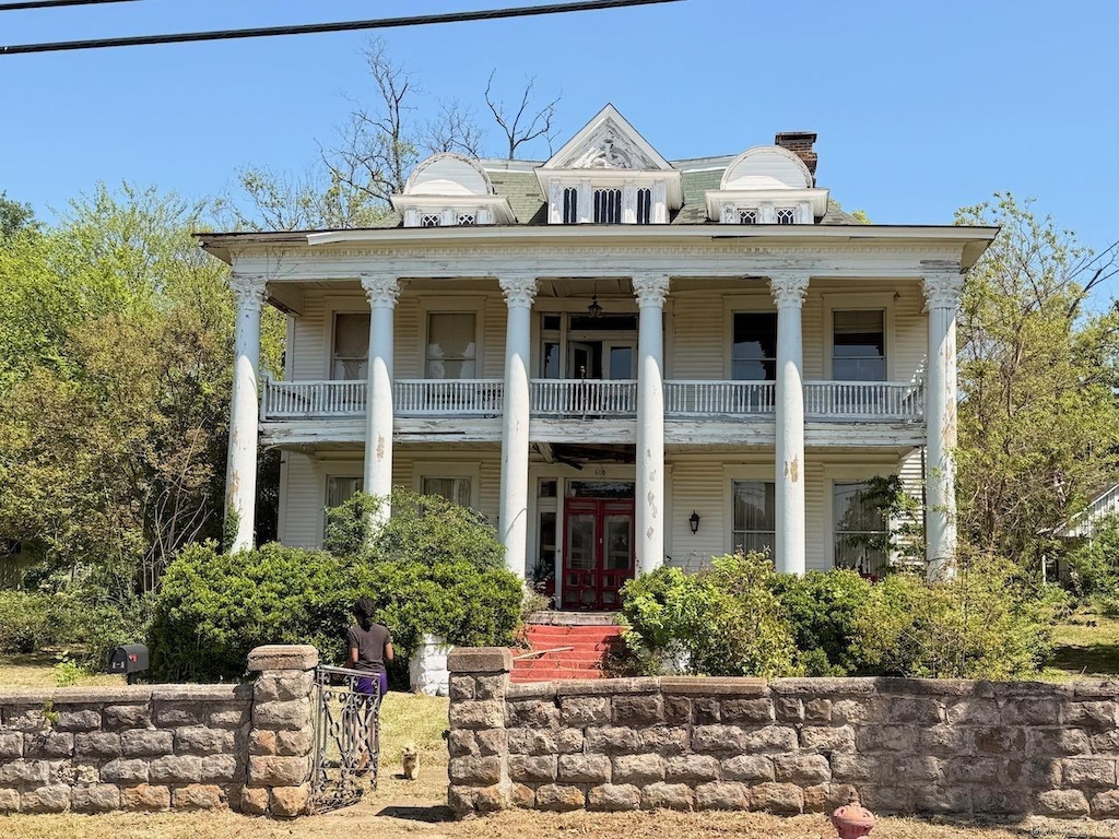 greek revival inspired property with french doors and a balcony