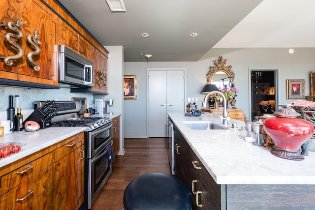 kitchen with tasteful backsplash, visible vents, a center island with sink, appliances with stainless steel finishes, and a sink