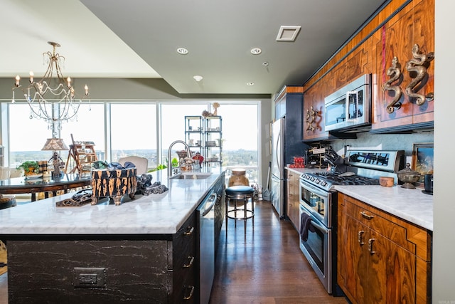 kitchen with an inviting chandelier, a sink, visible vents, and stainless steel appliances