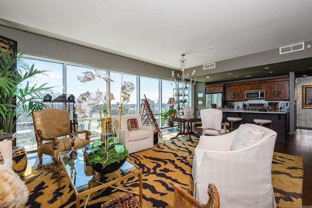 living area featuring wood finished floors, a notable chandelier, and visible vents
