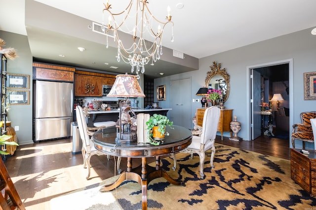 dining area with visible vents, light wood-style flooring, and a chandelier