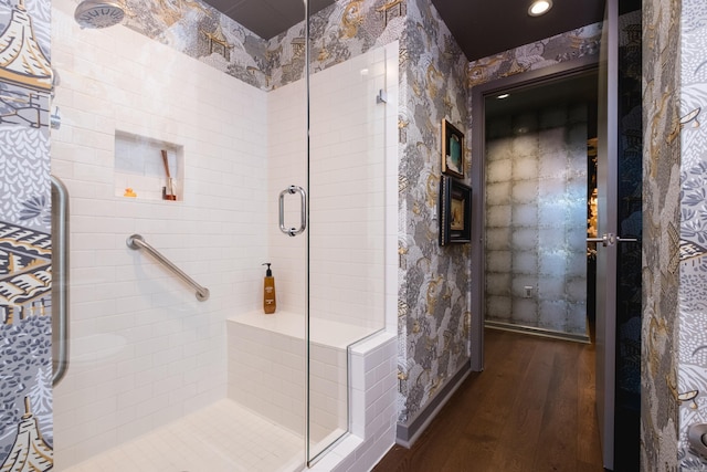 bathroom featuring a stall shower, wood finished floors, and wallpapered walls