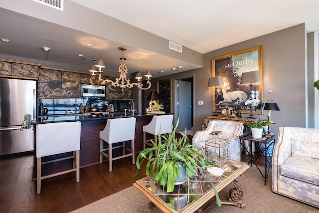 living area featuring a chandelier, dark wood-type flooring, and visible vents