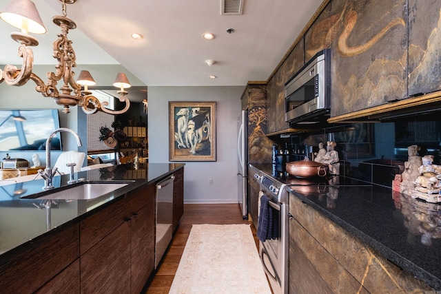 kitchen featuring baseboards, dark wood-type flooring, visible vents, appliances with stainless steel finishes, and a sink