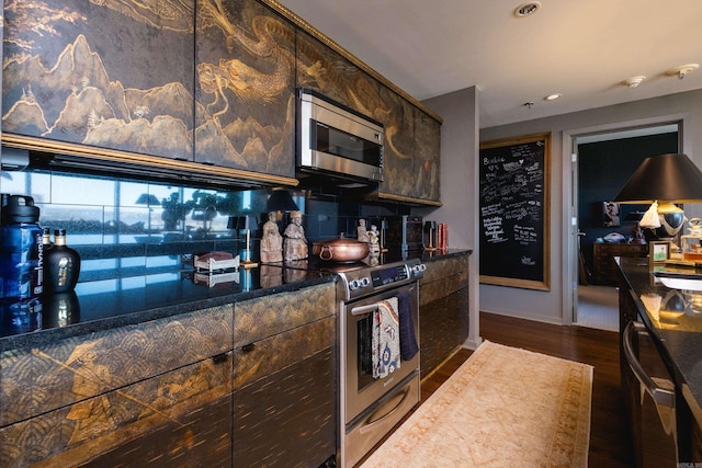 kitchen with recessed lighting, appliances with stainless steel finishes, dark wood-style flooring, dark countertops, and baseboards